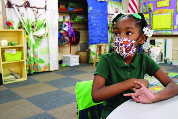 08-23-2020-return-to-school---Masked-student-sits-at-her-school-desk