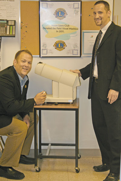 Dr. Scott Blomberg, an optometrist with Vision Care Associates in Springfield who volunteers at St. Clare’s Health Clinic in Springfield, explains how a field visual screen instrument works. Seated at the machine is James Hochenyos, president of the Springfield Noon Lions Club, who was on hand that day to present a check for $4,025 from the Lions to put toward the purchase of the machine. Another $1,000 came from an annual grant from Springfield Rotary South.
